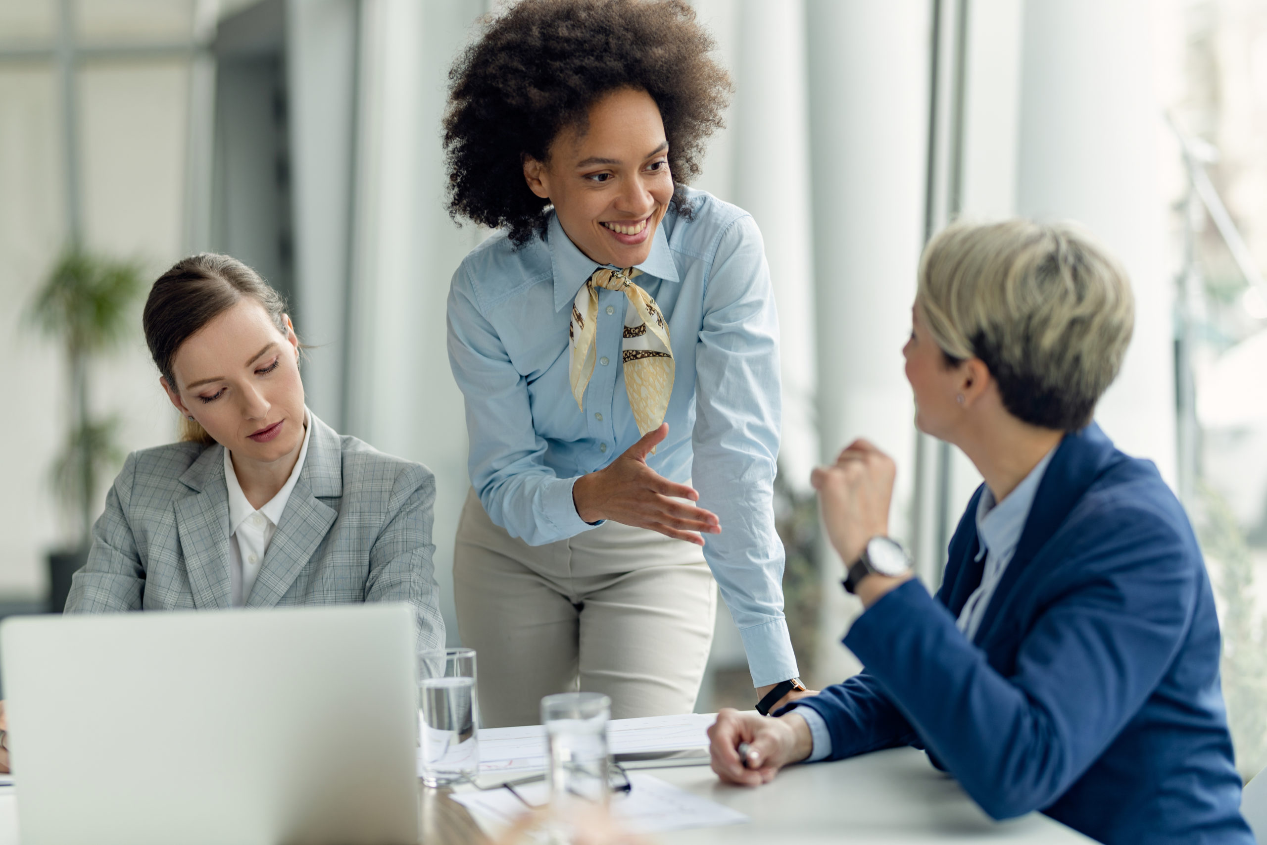Happy African American businesswoman talking to female colleague